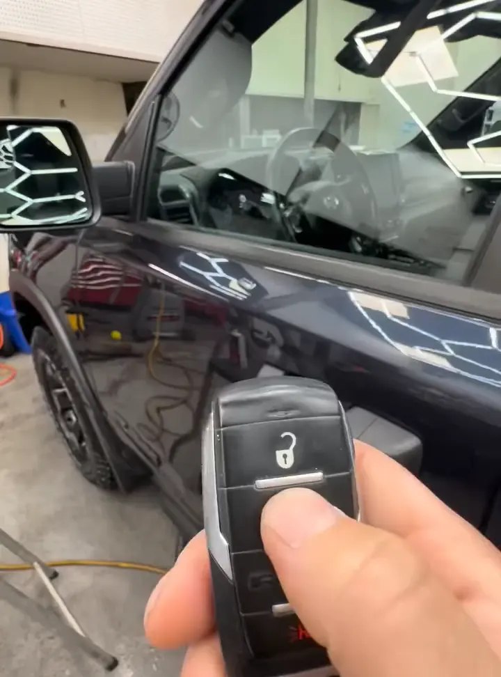 A Compustar remote in hand next to the truck it starts